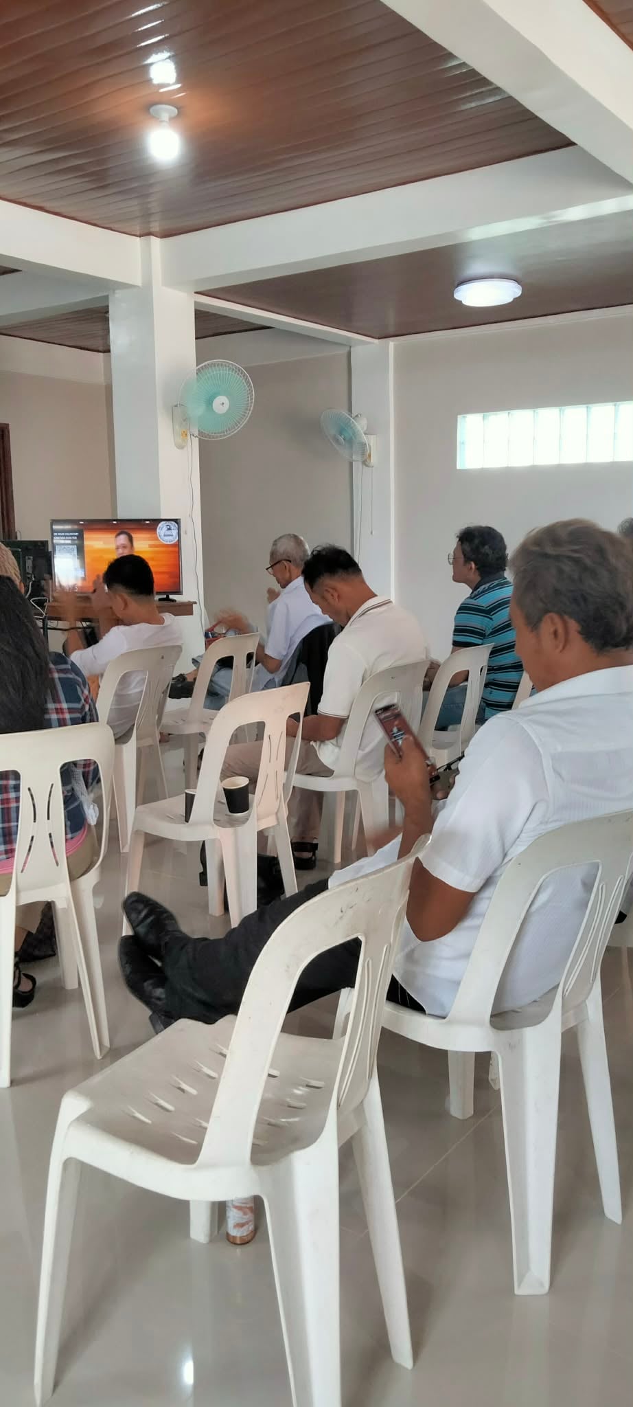 Attendees watching a Bible study broadcast together on a television screen